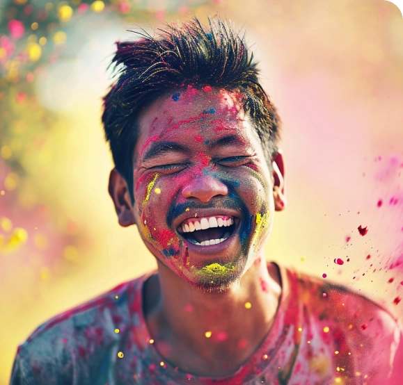 A man is laughing while he is covered in colored powder.