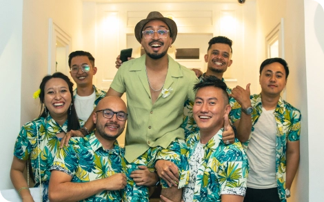 A team of employees posing for a group photo, with one member lifted in the air by the others in a moment of celebration.